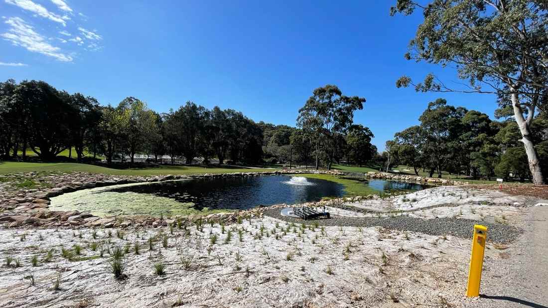 Golf course irrigation storage dam with fountain aerator, illustrating turf irrigation water quality management